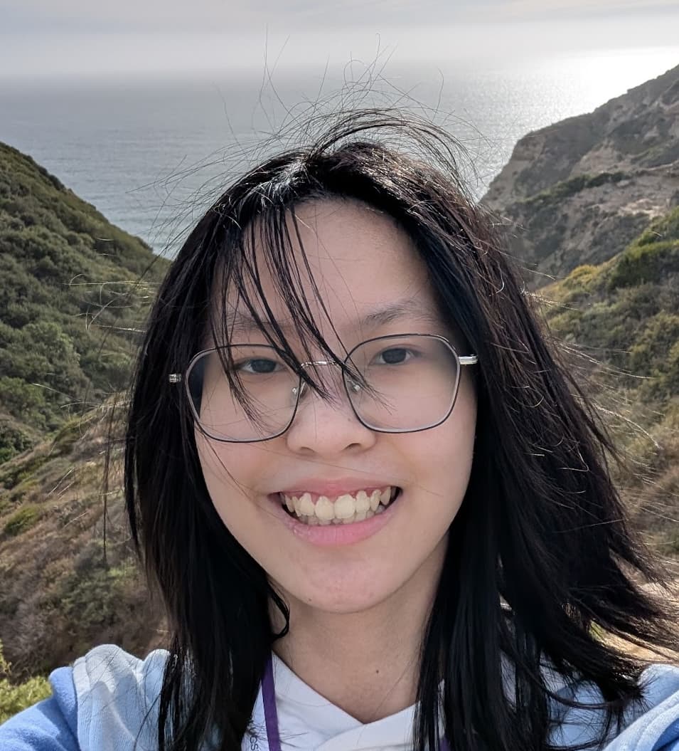 Isabel Ku outdoors with scenic ocean and hills background